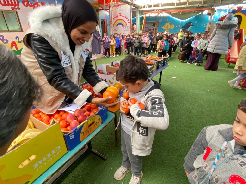 Distribution of fruit baskets to children in Deir al-Balah, supported by (WCK)